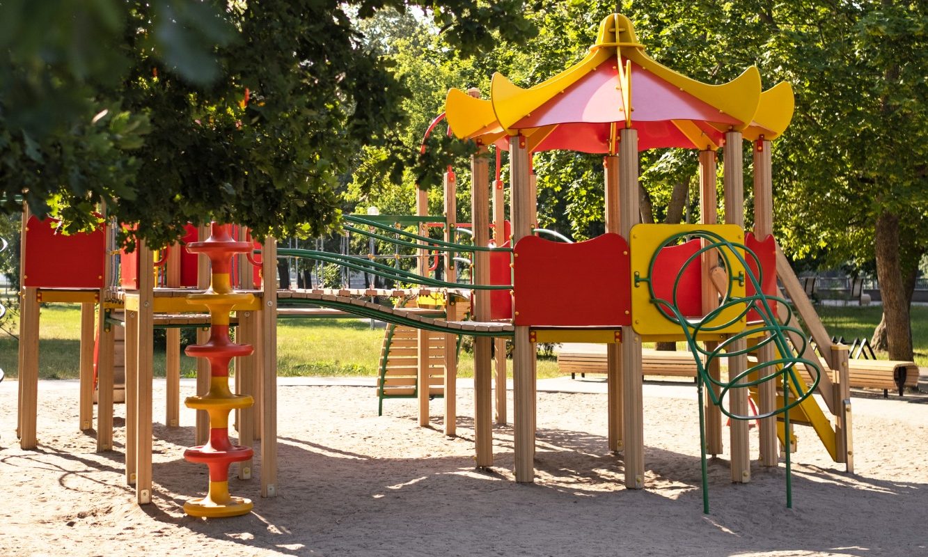 Spielplatz mit Rutschen, Klettergerüst und Sonnenschutzdächern in einer grünen Umgebung. Sonnensegel, Schutz für Kinder, Rutschen, Tunnel,